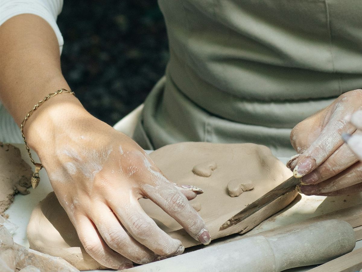 Mani di un’artigiana mentre modella l’argilla